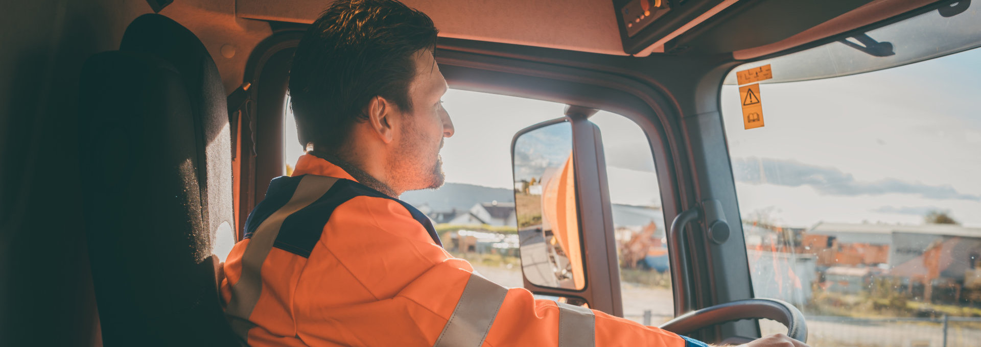 garbage removal worker driving a dump truck