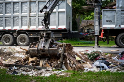 large truck picking up trash and debris outside