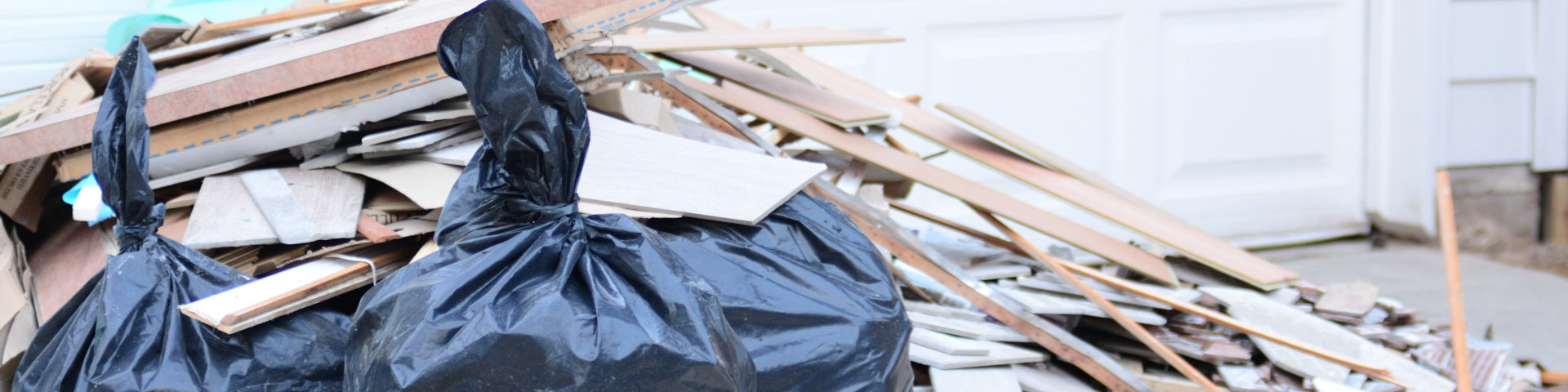 Construction debris in a pile outside of home remodel with flooring tiles